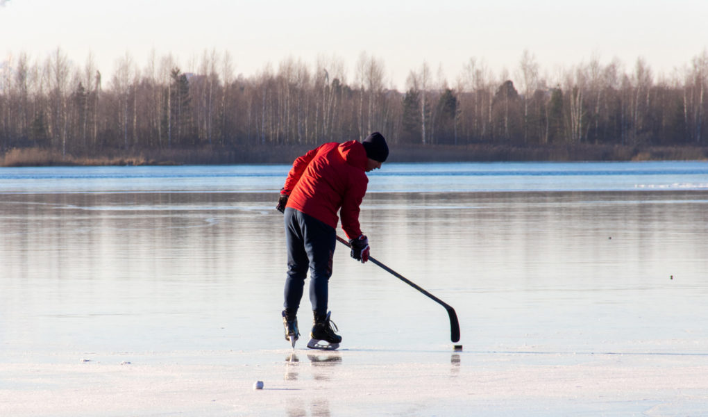 man plays hockey on the lake. Outdoor recreation. Lifestyle. Sports in a person's life.