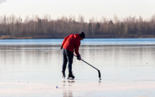 man plays hockey on the lake. Outdoor recreation. Lifestyle. Sports in a person's life.