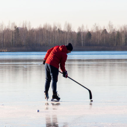 man plays hockey on the lake. Outdoor recreation. Lifestyle. Sports in a person's life.