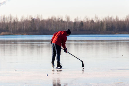 man plays hockey on the lake. Outdoor recreation. Lifestyle. Sports in a person's life.