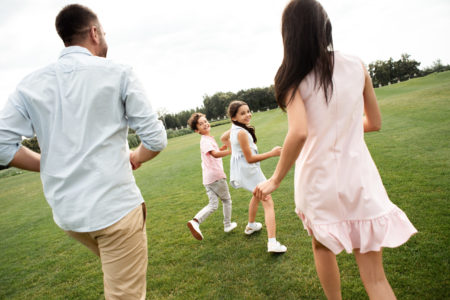 Spending time with kids. Back view of young active family playing together while spending free time